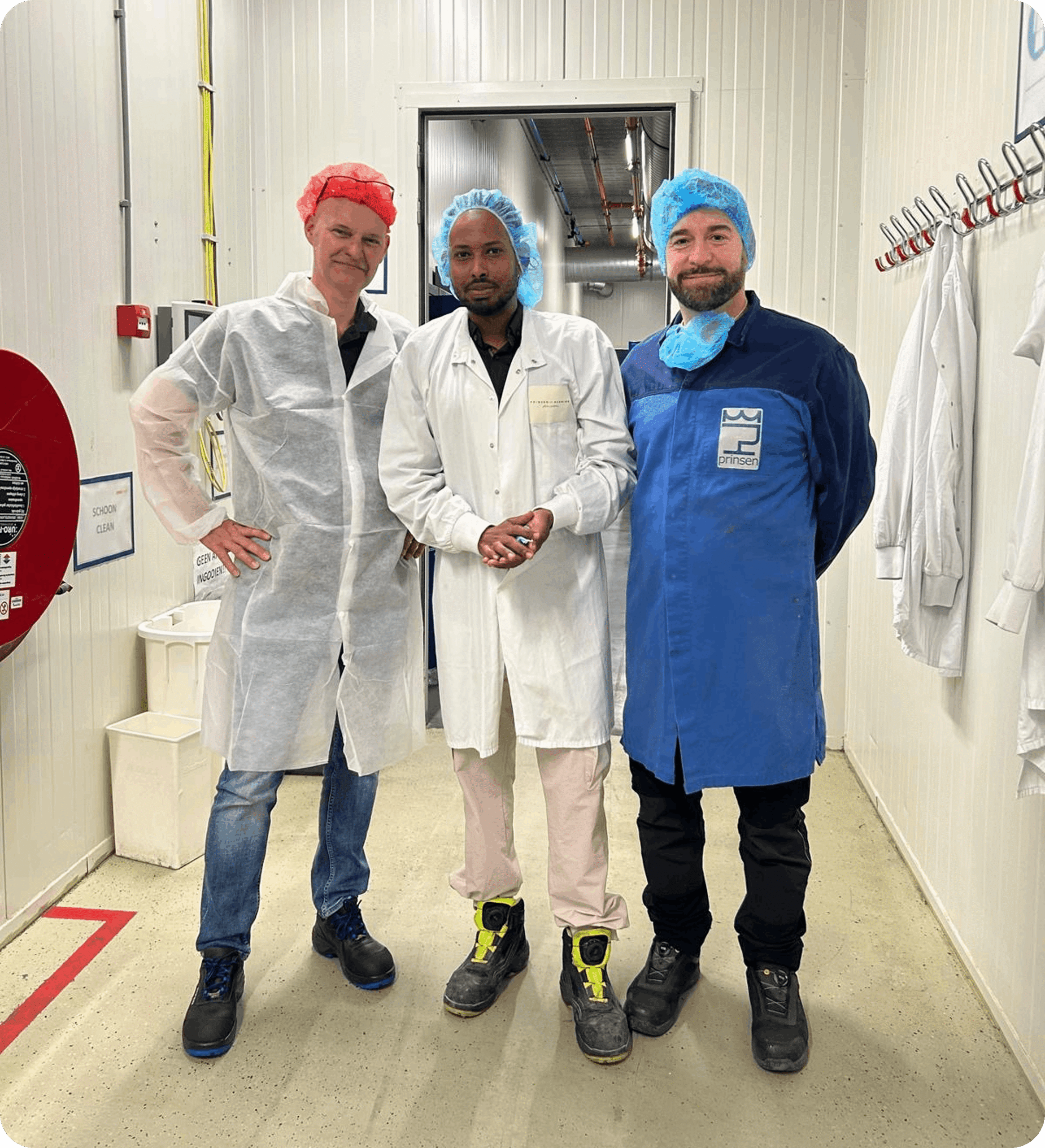 Medewerkers in bedrijfskleding in een productieomgeving tijdens een taaltraining